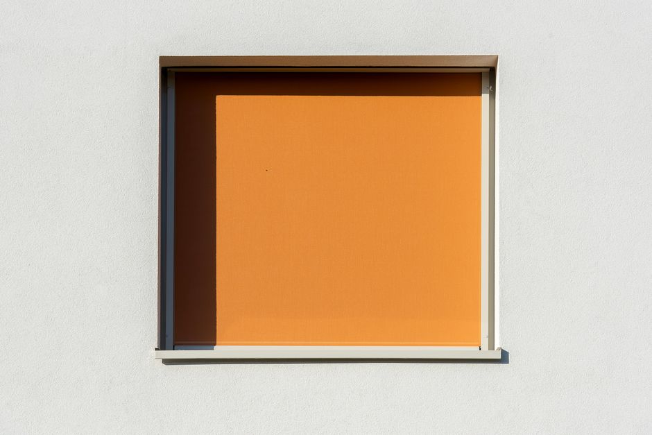 Warme rolgordijnen verlichten gezellige woonkamer.
